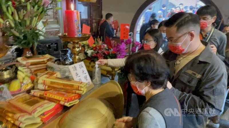 按民間傳統習俗大年初一走春,12日民眾紛紛到廟宇上香祈福,雲林縣北港朝天宮福德殿前有擺放一個金元寶,讓民眾求財,因應防疫政策,廟方特別在金元寶旁擺放消毒酒精,提醒民眾防疫優先。中央社記者姜宜菁攝 110年2月12日