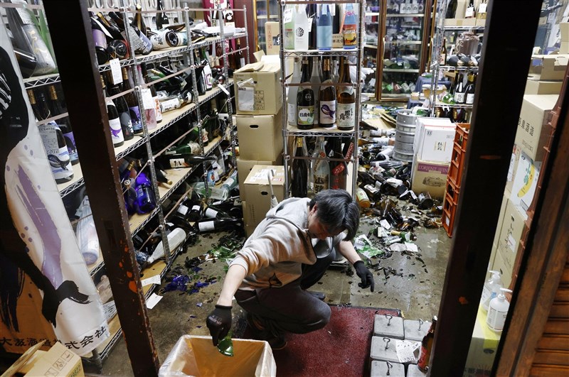 日本東北外海13日晚間發生規模7.1強震,福島一家商店內的酒瓶被震落一地。(共同社)