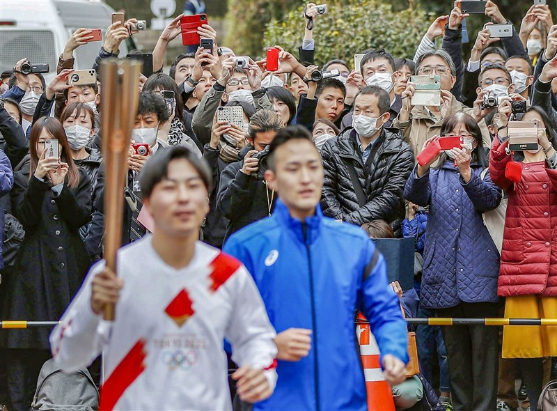 日本島根縣知事丸山達認為政府與東京都因應武漢肺炎防疫不力,他表示,若不改善,島根縣不得不取消東京奧運聖火傳遞。圖為東京民眾去年2月15日觀看東京奧運聖火傳遞彩排。(共同社)