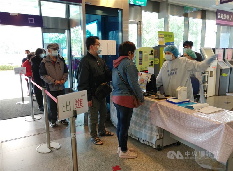 桃園醫院群聚案告一段落,19日恢復正常營運,民眾戴口罩排隊準備實名制登記入院。中央社記者施宗暉攝 110年2月19日