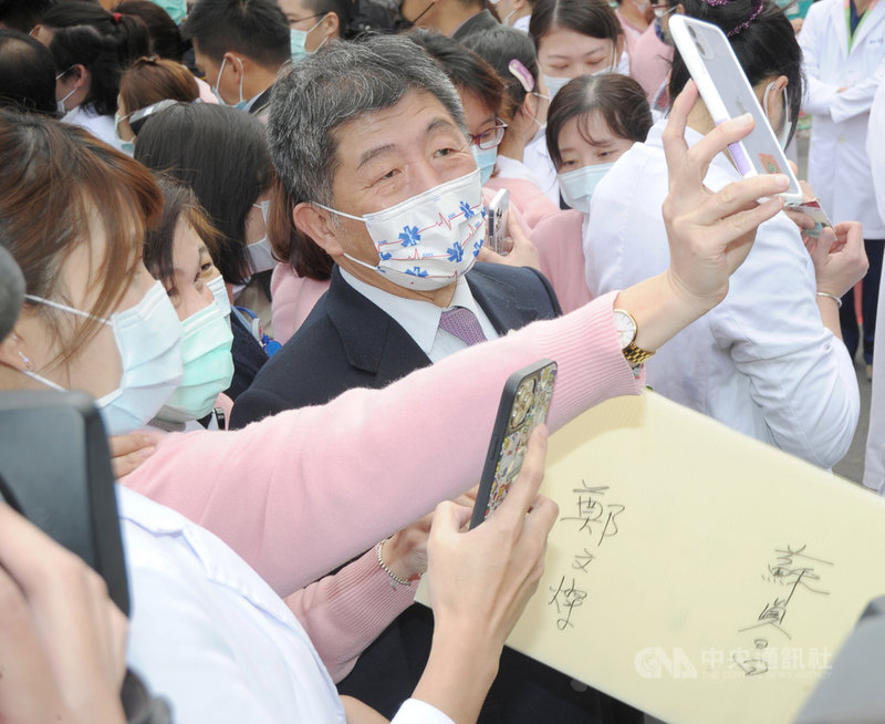 衛福部長陳時中(中)19日出席桃園醫院「復原啟動、防疫歸隊」記者會,受到醫護人員熱情歡迎,爭相與陳時中合影。中央社記者施宗暉攝 110年2月19日