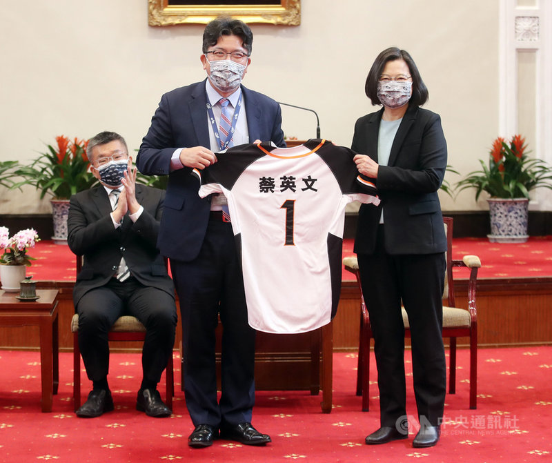 總統蔡英文(右)22日在總統府接見「2020年中華職棒總冠軍統一7-ELEVEn獅隊」,球團董事長凃忠正(中)致贈球衣給蔡總統。中央社記者張新偉攝 110年2月22日