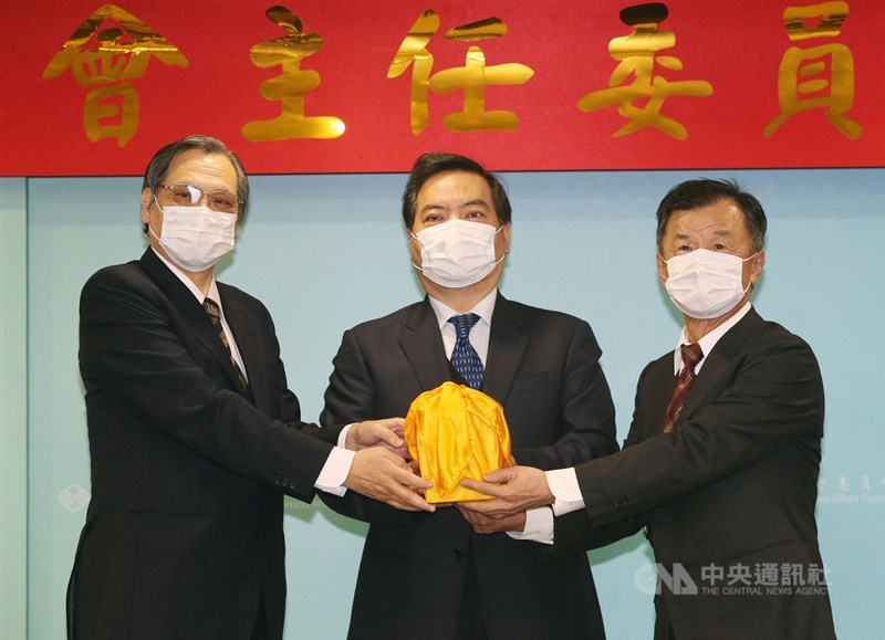 大陸委員會23日舉行主任委員交接典禮,卸任主委、新任國安局長陳明通(左)在政務委員羅秉成(中)監交下,將印信交給新任陸委會主委邱太三(右)。中央社記者郭日曉攝 110年2月23日