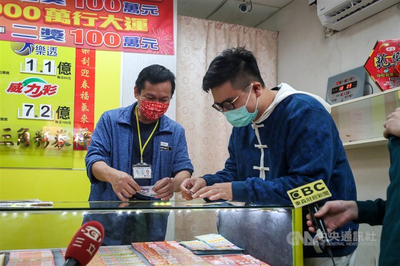 位於台北市大同區的「金三角彩券行」大年初四(15日)開出「2000萬超級紅包」三獎新台幣100萬元,幸運得主林先生(右)23日現身受訪表示,初四凌晨想玩刮刮樂,一路尋找還開門的彩券行,終於找到一間,隨手刮了3張就幸運中百萬。中央社記者裴禛攝 110年2月23日