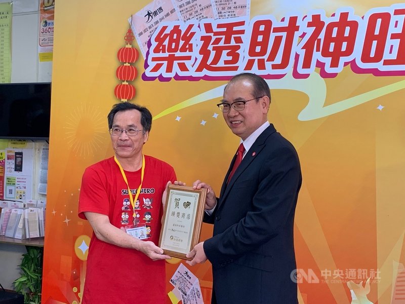 台灣彩券公司總經理蔡國基(右)25日南下高雄致贈「頭獎商店」獎牌給日前開出大樂透頭獎的鑫彩紅彩券行業者葉春發(左),祝賀幸運之神降臨。中央社記者王淑芬攝 110年2月25日