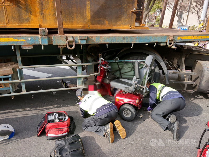 新竹縣湖口鄉光復北路與工業三路交叉口25日發生車禍,一名婦人騎三輪代步電動車與拖板車疑擦撞,婦人卡在車底,救護人員獲報到場救援,但送醫途中婦人失去呼吸心跳,急救後仍宣告不治。(讀者提供)中央社記者郭宣彣新竹縣傳真 110年2月26日