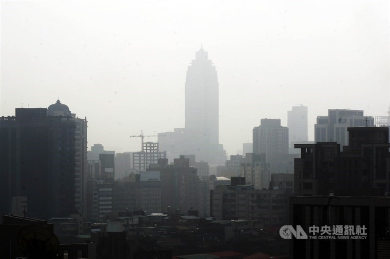 環保署25日表示,台灣北部、竹苗到中部空氣品質達紅色警示等級,提醒所有族群應減少在戶外活動,敏感族群應減少在戶外劇烈活動。圖為台北站前新光三越大樓幾乎隱沒在霧霾中。中央社記者孫仲達攝 110年2月25日