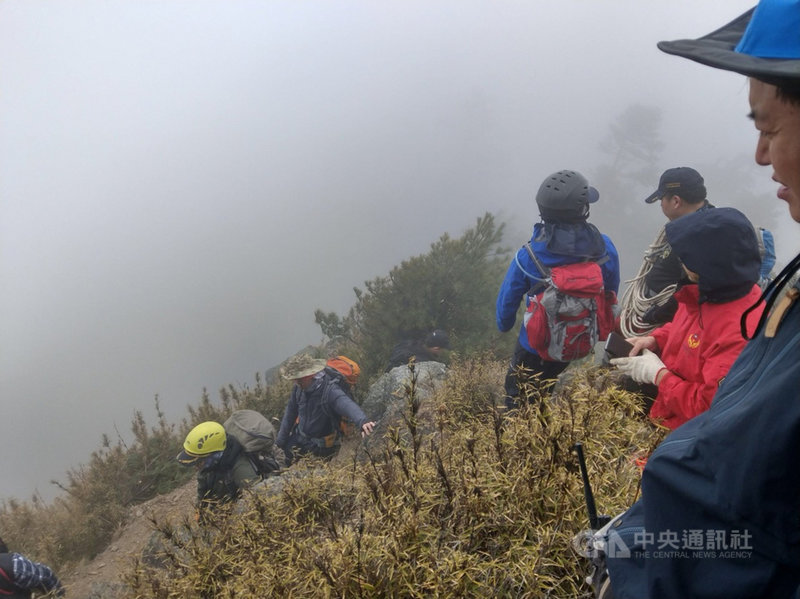 南投縣信義鄉發生山難死亡意外,34歲黃姓女子和友人攀登郡大山,登頂折返時失蹤,南投縣消防局派出搜救人員入山進行搜救(圖),27日下午發現黃女遺體,陸續由直升機協助將遺體吊掛下山。(翻攝照片)中央社記者吳哲豪傳真 110年2月27日