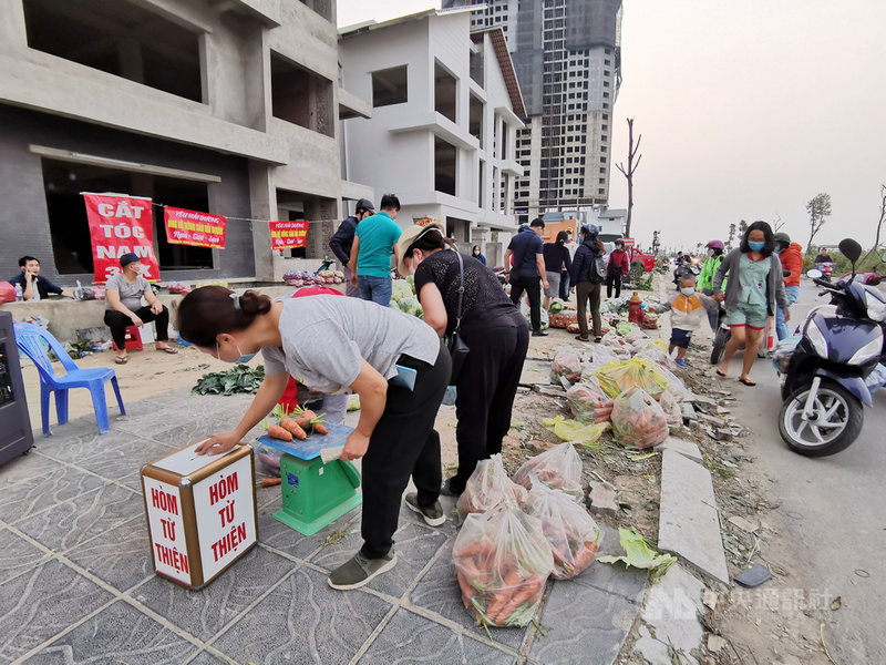 河內市街頭2月下旬以來陸續冒出許多臨時菜攤,背後由各組織與網友串聯,一起協助銷售海陽省農產品,盼疫情封鎖措施不至於影響農民生計。圖為河內市河東區一處海陽省農產品銷售據點。中央社記者陳家倫河內攝 110年2月28日