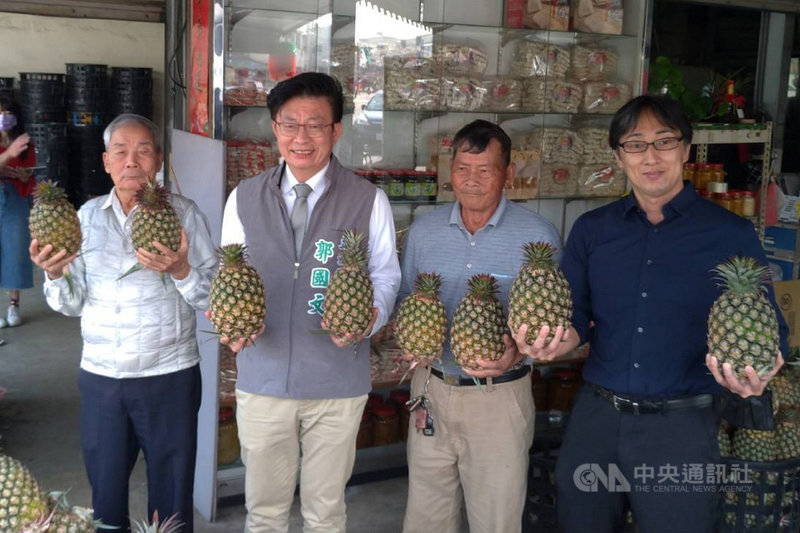 台南市民進黨立委郭國文(左2)發起支持鳳梨農民行動,獲得定居在台南的拉麵連鎖店日籍社長野崎孝男(右1)響應,28日前往關廟區的鳳梨產地,採購共3110公斤鳳梨。(郭國文服務處提供)中央社記者楊思瑞台南傳真 110年2月28日
