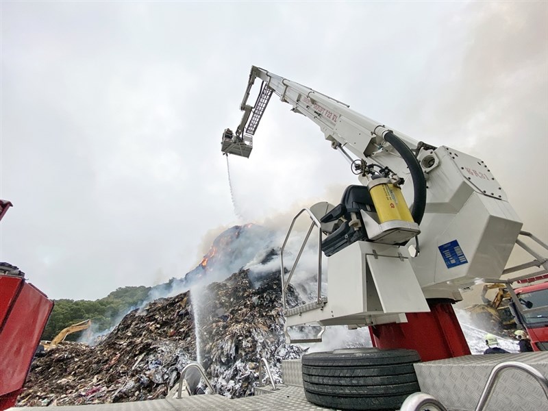 新北市八里垃圾掩埋場2日持續悶燒,消防局和環保局人員調派機具開挖處理。(新北市環保局提供)中央社記者黃旭昇新北傳真 110年3月2日