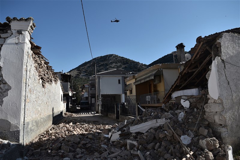 希臘中部3日發生規模6.3強震,造成上百棟建築受損。圖為一台軍用直升機飛過震央附近的達馬西村。(法新社)