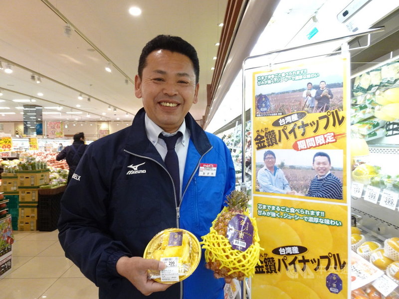日本連鎖超市BELX的青果商品部課長小川能弘特別在台灣鳳梨專區掛著他去年2月在屏東與果農的合照做宣傳。他說今年進口台灣鳳梨數量將是去年3倍。中央社記者楊明珠東京攝 110年3月5日