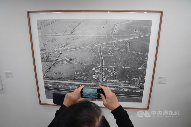 國家攝影文化中心台北館8日舉行首檔國際展「塵與時:從宇宙到居所」開箱記者會,與會人員拍攝Sophie Ristelhueber的作品。中央社記者徐肇昌攝 110年3月8日