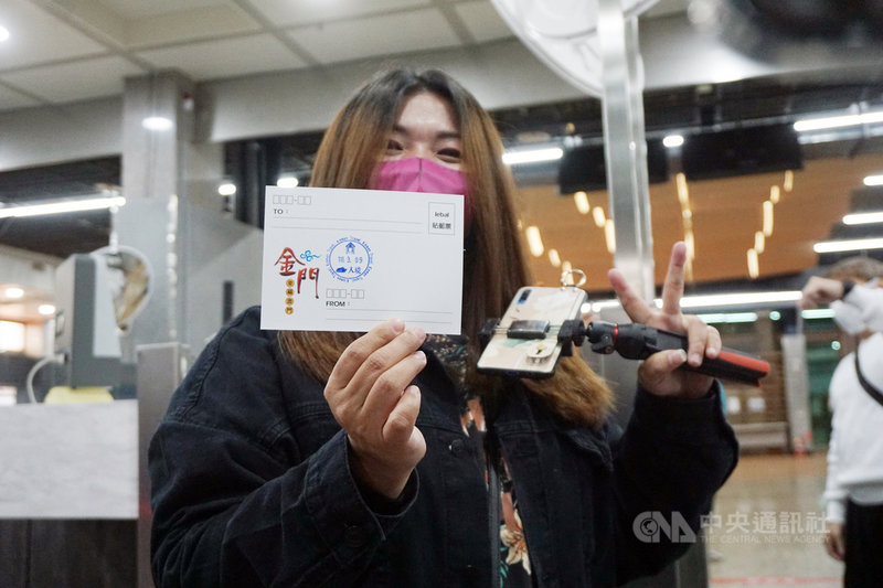 2021年度跳島遊旅客9日抵達金門。旅客循小三通模式入境通關,入關前獲贈金門景點明信片,再由海關人員在明信片上蓋上「入境」戳章。中央社記者黃慧敏攝 110年3月9日