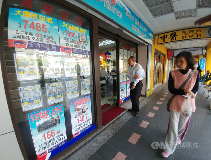 行政院會11日通過「房地合一」所得稅法修正草案,修正「短期持有」定義,個人、法人持有2年內賣房將課45%;持有超過2年、未逾5年課35%;全案將送立法院審議。圖為民眾經過房仲業者店外,關注售屋資訊。中央社記者施宗暉攝 110年3月11日