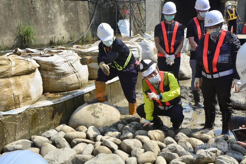 新北市長侯友宜（前右2）11日在中和區藤寮坑溝體驗砌石，向有經驗的師傅學習以人工施作堆疊的訣竅，希望能為排水溝與河川，創造多樣性的天然環境。中央社記者黃旭昇新北攝  110年3月11日