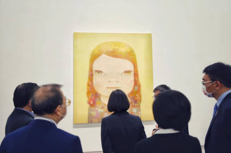 日本藝術家奈良美智畫作「朦朧潮濕的一天」將於台灣展開10年巡展計畫「跟著朦朧潮濕的一天去旅行」。圖為2021年奈良美智特展，總統蔡英文（中）欣賞畫作「朦朧潮濕的一天」。（©YOSHITOMO NARA／文化總會提供）