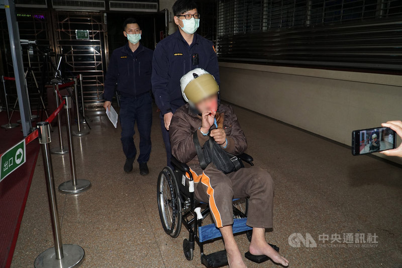 洪姓男子(前)13日清晨駕車衝撞台北市警察局文山第一分局門口,之後再轉到後方停車場衝撞警車,除洪男輕傷外,幸未再造成人員受傷。台北地檢署檢察官晚間複訊後,要求警方戒護洪男強制就醫。中央社記者蕭博文攝 110年3月13日