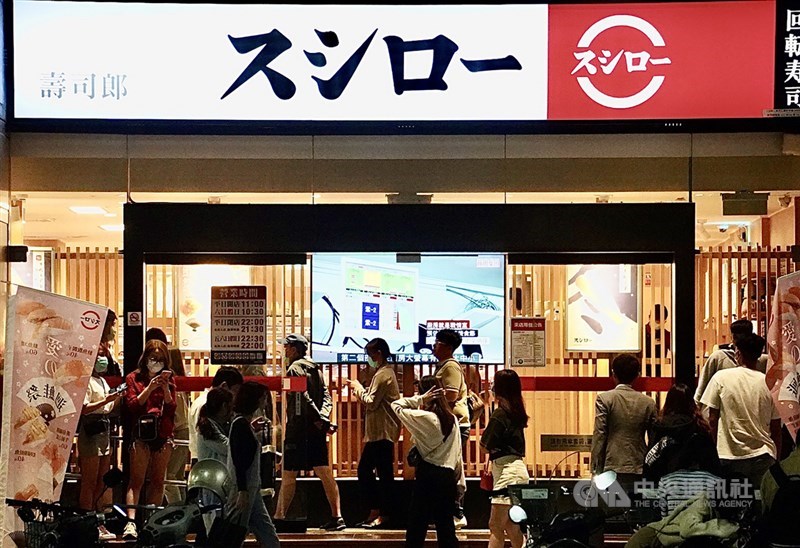 日本知名連鎖迴轉壽司店17、18日推出「愛的迴鮭,尋人啟事」活動,姓名中有「鮭魚」同音同字就能享「全桌免費」,同音也能享5折優惠,意外在六都吸引近百人爭相改名「鮭魚」。圖為業者在高雄一家門市,17日晚間民眾排隊等候用餐。中央社記者董俊志攝 110年3月17日
