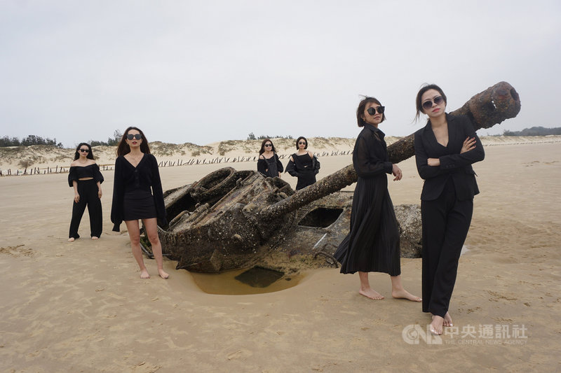 金門縣政府攜手華信航空,從3月初號召百名空服員分批來金旅遊,6名高值顏空服員18日來到金門歐厝海邊,親眼目睹「沉睡戰車」,爭相擺出美姿與戰車合影。中央社記者黃慧敏攝 110年3月18日