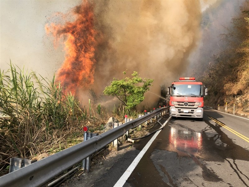 嘉義縣達邦公路18日下午發生林班地火警,一路往上燃燒,燒到台18縣阿里山公路下方,消防車在阿里山公路上灌水滅火,阿里山公路68.7K到69.2K進行機動交通管制。(嘉義縣消防局提供)中央社記者蔡智明傳真 110年3月19日
