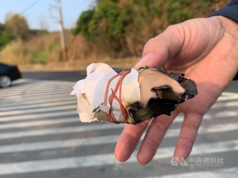 陳姓老農為驅趕偷吃農作物猴群,自製數顆紙張包石頭的引燃器,與鞭炮一起點燃後,丟往旗尾第三登山口附近草叢,豈料引發火燒山。(高市旗山警分局提供)中央社記者洪學廣傳真 110年3月23日