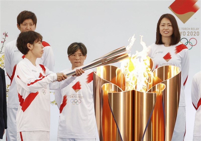 曾在2011年女子世界盃足球賽奪冠、被暱稱為「大和撫子」的日本國家女子足球隊16名成員擔任東奧聖火傳遞第一棒跑者,成員之一的岩清水梓(前)25日點起聖火火炬。(共同社)