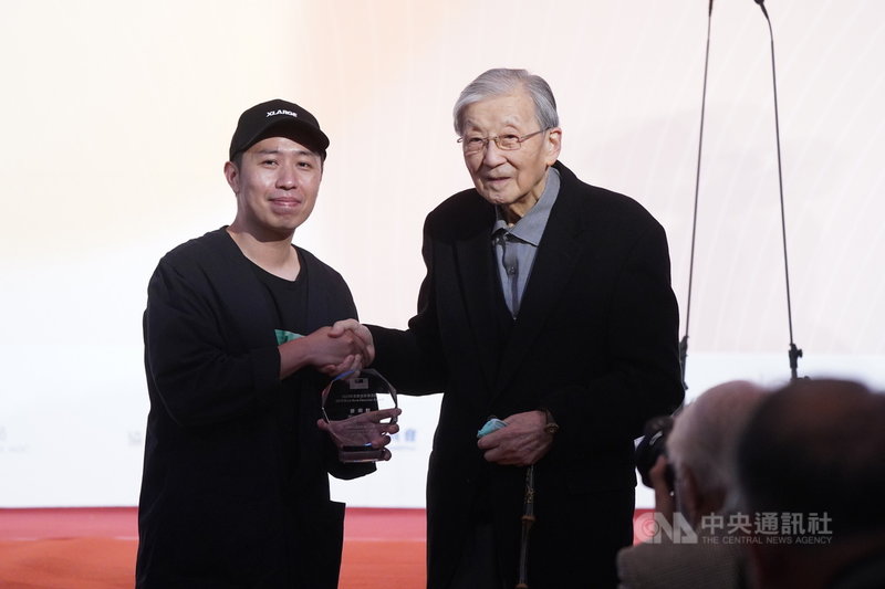第一屆「年度傑出影視聽工作者頒獎典禮」26日在台北市中山堂舉行,導演李行(右)頒發2020年最佳新導演獎給導演廖明毅(左)。中央社記者徐肇昌攝 110年3月26日
