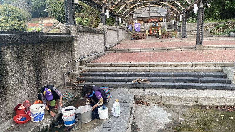 水情告急,被列為彰化縣歷史建築的彰化市八卦山紅毛井,井水仍不斷湧出,住在紅毛井附近的婆婆媽媽照常取水洗衣。中央社記者吳哲豪彰化攝 110年3月28日
