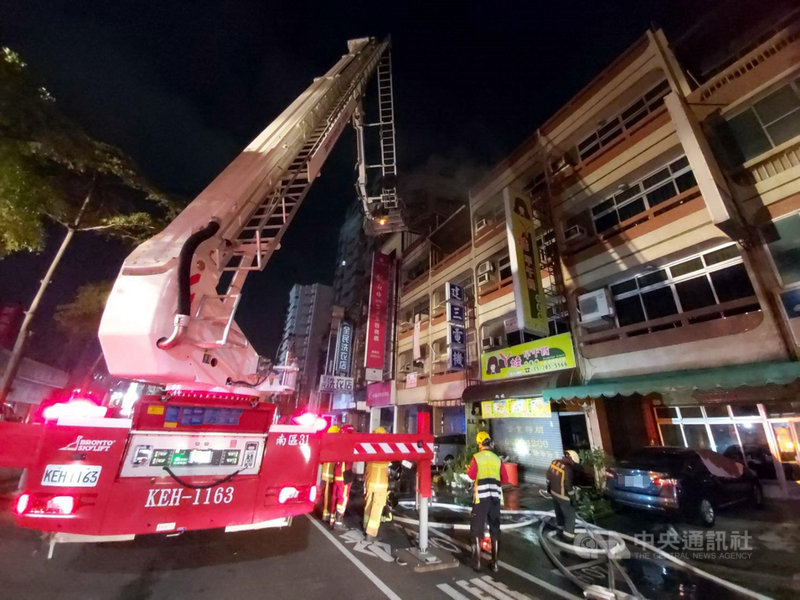 嘉義市新民路一處民宅29日凌晨發生火災,蔡姓婦人在3樓陽台求救,消防人員出動雲梯車搶救,並破門將受困臥室的黃姓老翁抬出,2人都送醫治療。(嘉義市消防局提供)中央社記者黃國芳傳真 110年3月29日