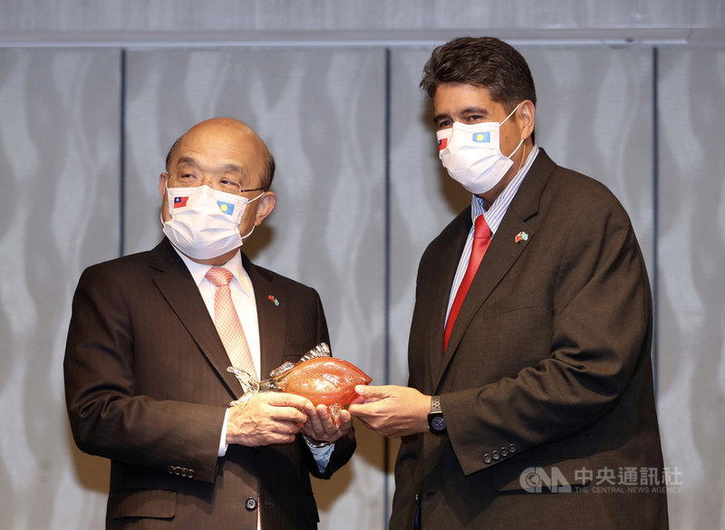 帛琉總統惠恕仁(Surangel Whipps Jr.)(右)率團訪台,行政院長蘇貞昌(左)29日晚間在台北宴請惠恕仁一行,惠恕仁致贈禮品給蘇貞昌。中央社記者張皓安攝 110年3月29日