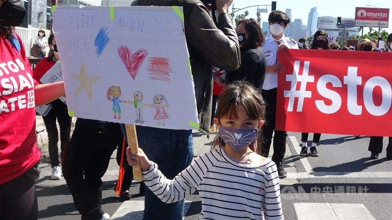 一名年幼小女孩帶著自製標語與家長一起遊行。中央社記者林宏翰洛杉磯攝 110年3月28日