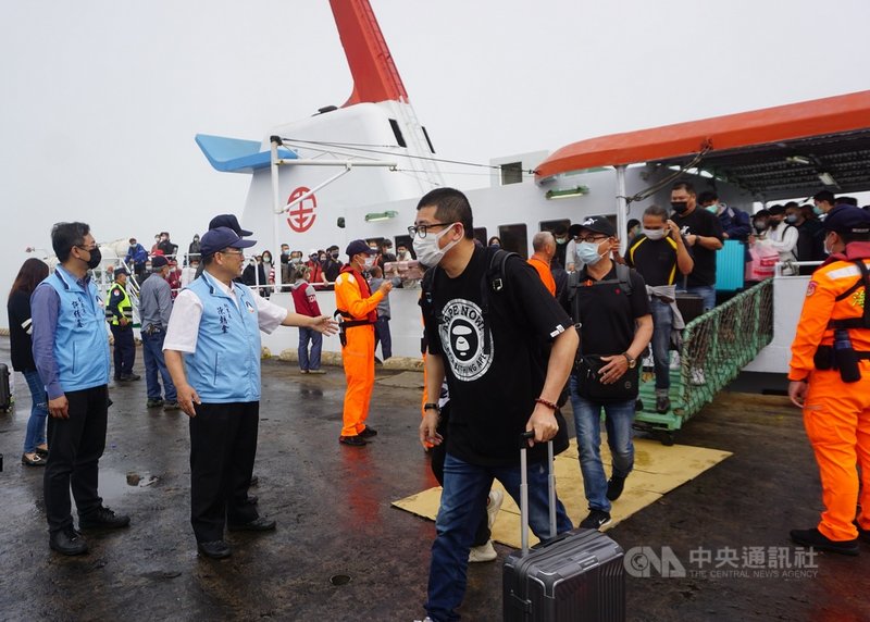 清明連假第一天，金門縣政府秘書長陳朝金（前左2）、觀光處副處長許績鑫（前左1）等人2日上午在料羅港碼頭迎接搭乘金門快輪的民眾。中央社記者黃慧敏攝  110年4月2日