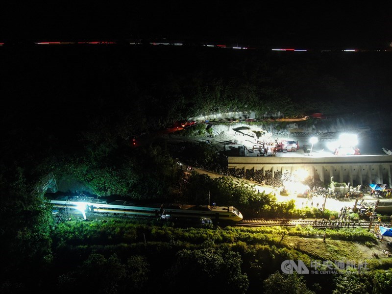 台鐵408次太魯閣號2日發生重大出軌意外,依據台鐵通報,交通受損狀況包括東正線中斷,西正線維持單線雙向運轉;列車第1至6車出軌、電桿1根傾倒、電車線扯落150公尺、導電軌400公尺扯落,目前4至8節車廂還卡在隧道內。圖為晚間事故現場仍燈火通明,持續進行相關作業。中央社記者吳家昇攝 110年4月2日