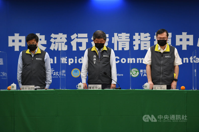 中央流行疫情指揮中心指揮官陳時中(中)、發言人莊人祥(右)、疫情監測組長周志浩(左)3日晚間在臨時記者會開始前,先為台鐵太魯閣號事故罹難者默哀1分鐘。中央社記者王飛華攝 110年4月3日