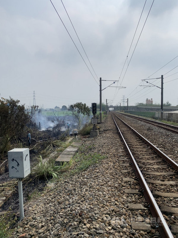 嘉義縣大林鎮緊鄰鐵軌一處空地8日下午發生雜草起火燃燒,消防局通報台鐵高壓電斷電進行滅火,一度影響火車通行,起火原因正由警方進一步調查。(台鐵提供)中央社記者蔡智明傳真 110年4月8日