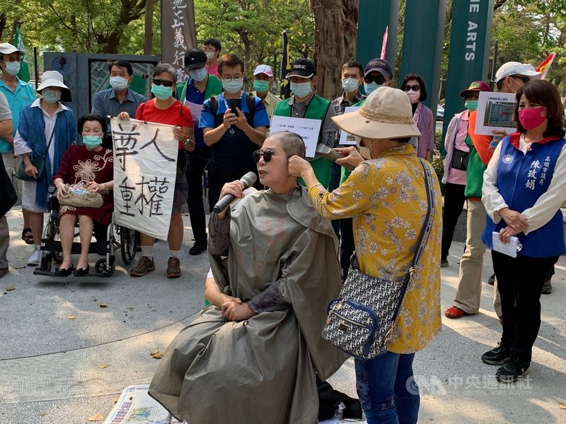 「高雄輕軌二階沿線居民自救會」數十名成員11日到美術館人行步道區,持手板及旗幟抗議,訴求輕軌路線北移20公尺進入美術館園區。中央社記者王淑芬攝 110年4月11日