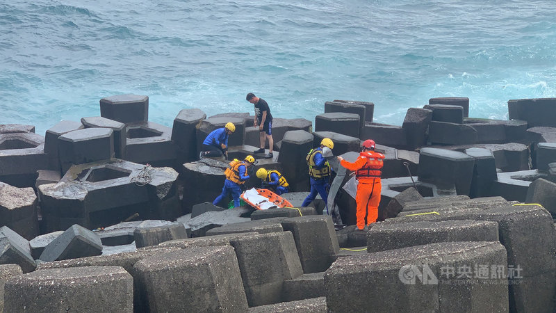 基隆市外木山海興游泳池附近一處消波塊11日上午發現一具男性遺體,搜救人員中午12時許將遺體拉上岸,由於死者身上沒有證件,身分仍有待警方調查。(讀者提供)中央社記者王朝鈺傳真 110年4月11日