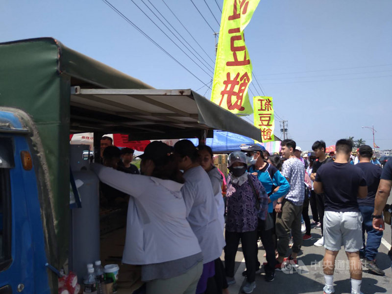 大甲鎮瀾宮媽祖遶境進香,鑾轎12日抵達嘉義,香客陸續進入新港鄉,沿途民眾提供各種免費飲料與食物,一名呂姓民眾則現做紅豆餅給香客取用。中央社記者蔡智明攝 110年4月12日