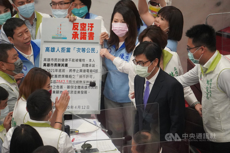 高雄市議會第3屆第5次定期大會12日進行市長施政報告及質詢,國民黨團約20名議員持「反空污承諾書」包圍市長陳其邁(前右2),促他簽署。中央社記者董俊志攝 110年4月12日