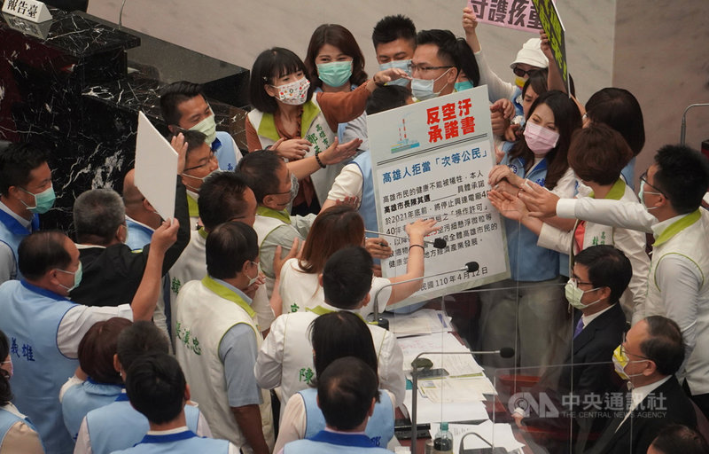 高雄市議會第3屆第5次定期大會12日進行市長施政報告及質詢,國民黨團約20名議員持「反空污承諾書」趨前包圍市長陳其邁(前排坐者右2)。中央社記者董俊志攝 110年4月12日