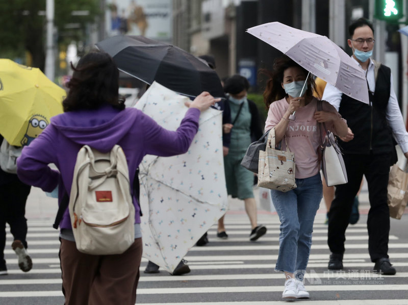 中央氣象局表示,13日白天各地大多為多雲到晴,隨著鋒面通過及東北季風增強,北台灣氣溫會逐漸下降,感受較涼,有局部短暫陣雨。圖為午後台北地區飄下細細雨絲,部分民眾撐傘擋雨。中央社記者張皓安攝 110年4月13日