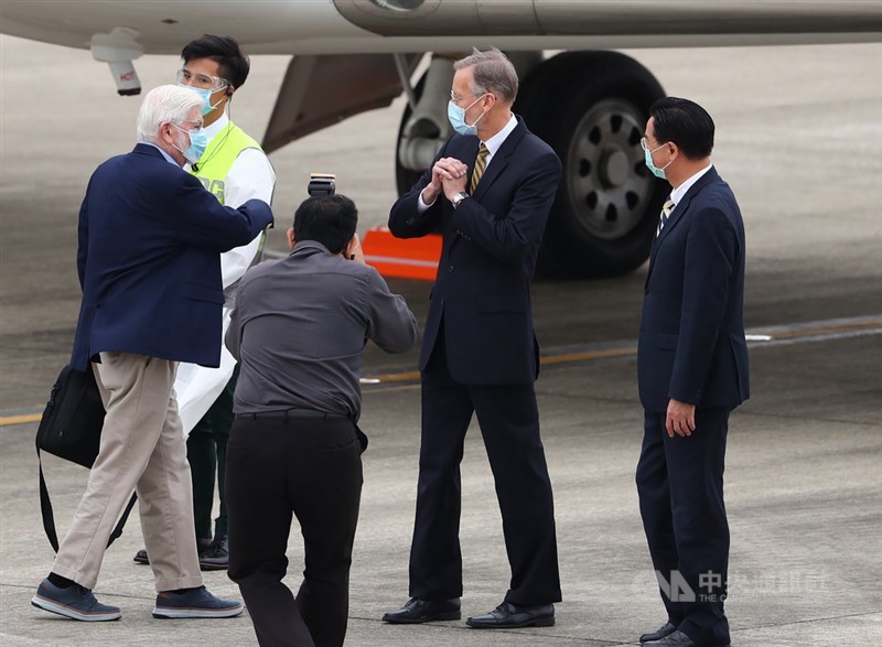 美國總統拜登摯友、前參議員陶德(Chris Dodd)(左白髮者)所率訪問團搭乘專機,14日下午飛抵台北松山機場,外交部長吳釗燮(右)、美國在台協會(AIT)處長酈英傑(William Brent Christensen)(右2)到場接機,酈英傑向陶德拱手致意。中央社記者王騰毅攝 110年4月14日