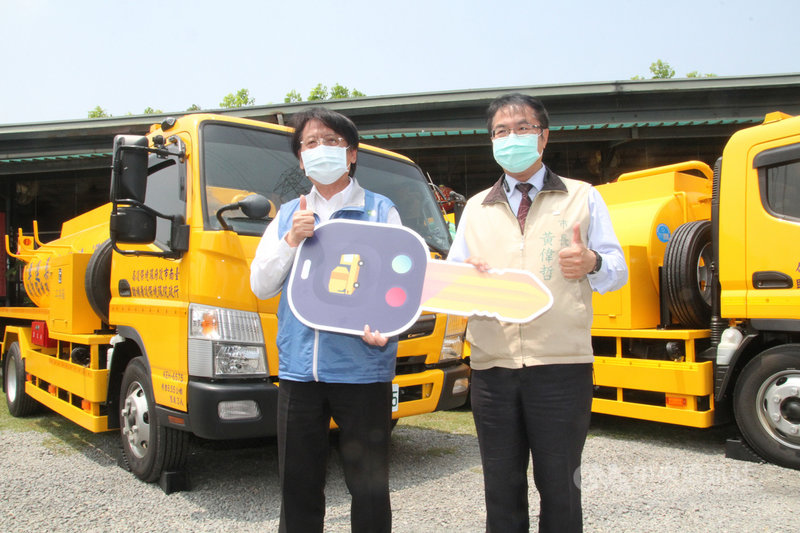台南市政府環保局15日在柳營八翁酪農區舉辦沼液沼渣集運輸車輛贈車儀式,由環保署副署長蔡鴻德(左)將鑰匙交到台南市長黃偉哲(右)手中。中央社記者楊思瑞攝 110年4月15日