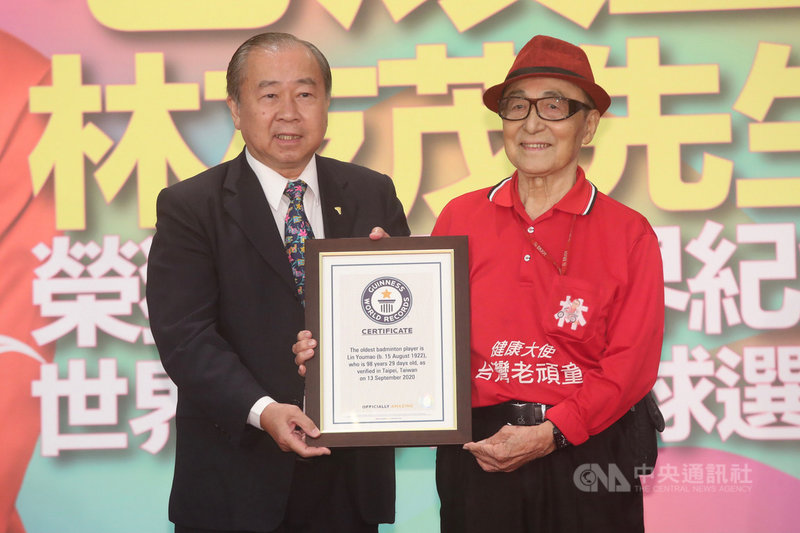 老頑童林友茂(右)榮獲金氏世界紀錄認證最年長羽球選手,16日舉辦記者會宣傳,林友茂從全球華人羽毛球聯合會會長吳俊彥(左)手上接過證書。中央社記者吳家昇攝 110年4月16日