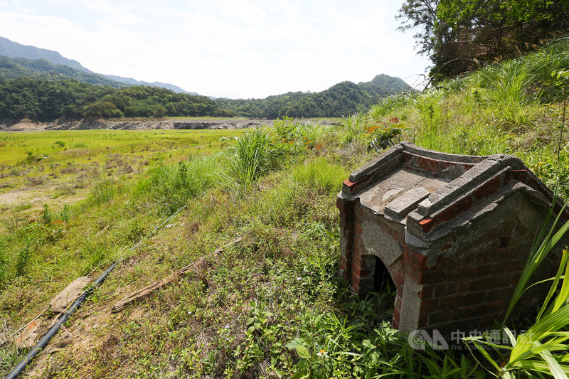 旱象嚴峻,當年因興建石門水庫而被淹沒的「阿姆坪土地公廟」如今也重見天日,且由於乾旱多時,周遭已長出不少青青雜草。中央社記者王騰毅攝 110年4月17日