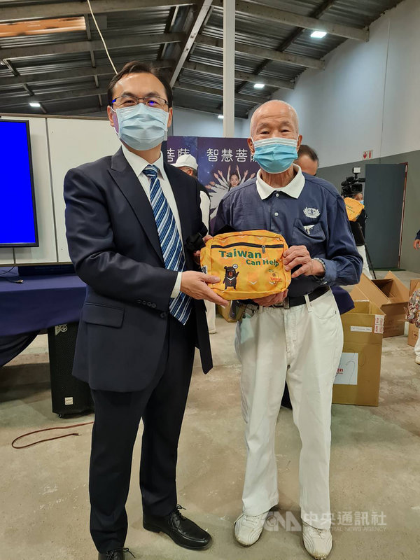駐南非代表賀忠義17日率領同仁拜會慈濟基金會南非分會。會後贈送慈濟志工每人1個印有 Taiwan can help的鵝黃色隨身小背包。圖為賀忠義(左)與慈濟資深志工張敏輝合影留念。(駐南非代表處提供)中央社記者徐梅玉約翰尼斯堡傳真 110年4月18日