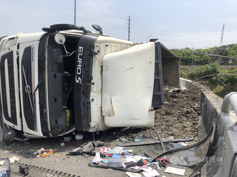 一輛載運廢土大貨車19日行經國道1號南下頭屋出口匝道時,疑載重過彎不慎側翻,駕駛受傷送醫。(民眾提供)中央社記者管瑞平傳真 110年4月19日