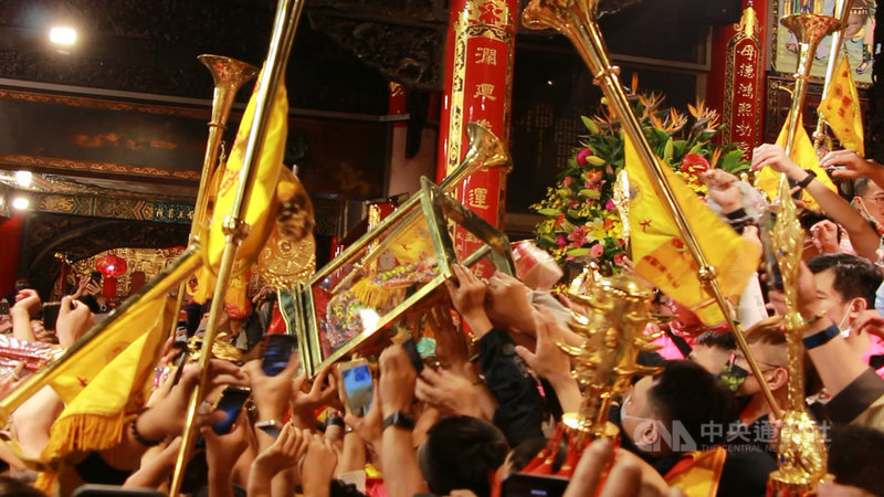 大甲媽祖鑾轎18日晚間回鑾鎮瀾宮安座,信徒一路擁簇跟隨,媽祖神轎入廟後,信眾紛紛擠上前爭相摸媽祖神像。中央社記者蘇木春攝 110年4月18日